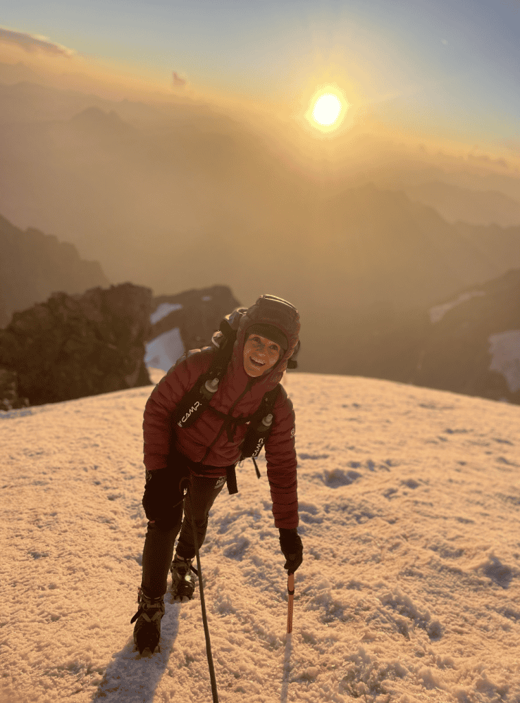 Chica subiendo montaña la Meije alpinismo nieve puesta de sol